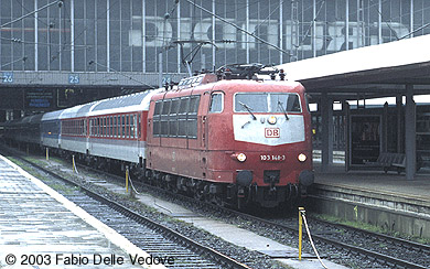 Zum Vergrößern klicken - Abfahrt von 103 148-3 mit dem IR 2120 SPESSART nach Würzburg um 16:29 Uhr von Gleis 25 bei strömendem Regen (München Hauptbahnhof, April 2001).
