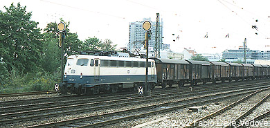 Die Bügelfalten-110 437-1 kommt mit einem Güterzug vom Rangierbahnhof München-Laim (München Heimeranplatz, August 1990)