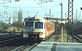 Ankunft vom orange-weißen 420 650-4 um 15:37 Uhr als S 20 (Deisenhofen - München Pasing) (München Hbf 15:25 - Klagenfurt Hbf 20:22) mit 1116 006-6 rauscht durch den Bahnhof Heimeranplatz (München, Frühling 2002).