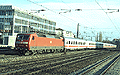 Die verkehrsrote 120 114-4 schiebt den IR 2097 (München Hbf 15:37 - Salzburg Hbf 17:23) durch den Bahnhof Heimeranplatz (München, Frühling 2002).