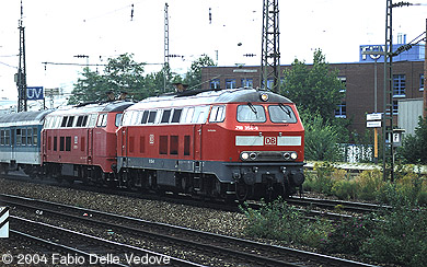 Die verkehrsrote 218 354-9 und eine orientrote 218 vor RB 31463 (München Hbf 15:14 - München Ost 15:22 - Mühldorf (Obb) - 16:19/16:28 - Simbach (Inn) 16:59) um 15:17 Uhr (München Heimeranplatz, September 2003).