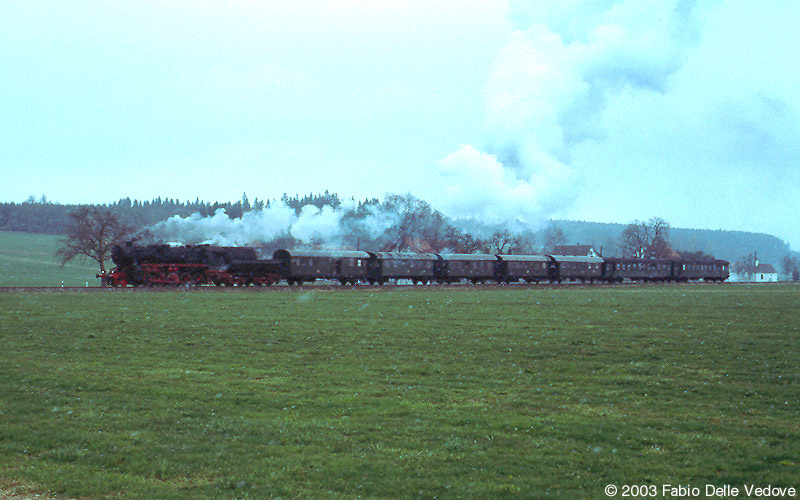 Bei leichtem Schneetreiben kommt die 52 7596 mit ihren 7 Wagen aus Bad Wurzach (Mennisweiler, 06. April 2003).